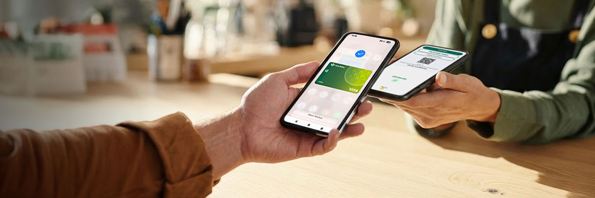 Ruralvía TPV Smartphone - Mujer joven pagando con su tarjeta de crédito en un TPV móvil de Caja Rural un comercio