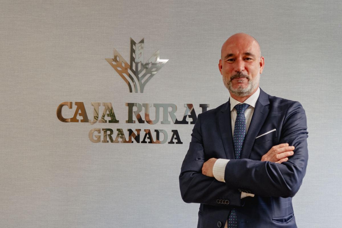 David Fenollar, director de la nueva oficina de Caja Rural en Murcia frente al logo de Caja Rural