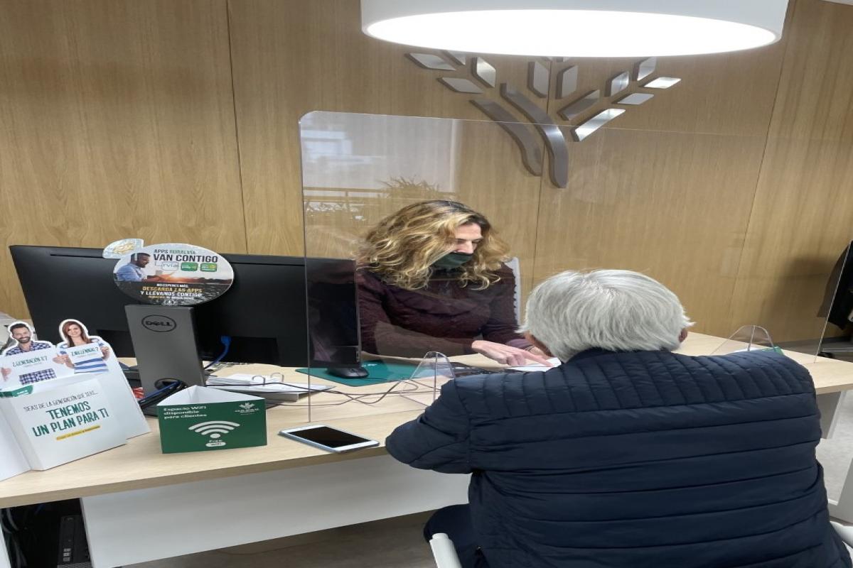 Personal de Caja Rural Granada atendiendo a un pensionista