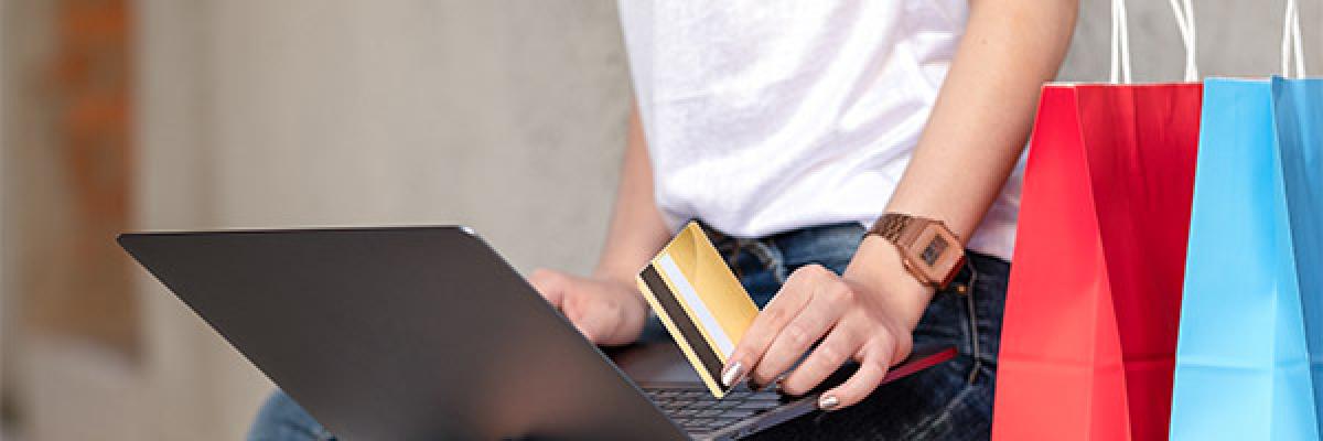 Servicio de Aplazamiento de pago para Particulares - Una chica, de compras, tiene en la mano una tarjeta de crédito Servicio de Aplazamiento de pago para Particulares - Una chica, de compras, tiene en la mano una tarjeta de crédito