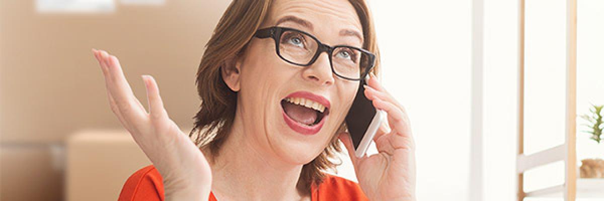 Programa Porque Somos Así Autónomos - Mujer de mediana edad autónomos gafas y camisa roja hablando por teléfono móvil desde su negocio