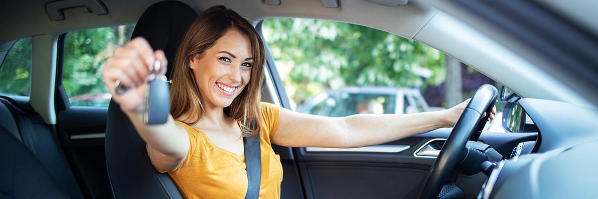 Mujer joven en un coche y mostrando las llaves - CRG Rural Renting Particulares